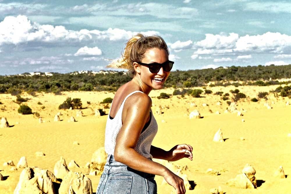 Entrevista trabajo chica rubia sonriendo de espaldas y delante desierto
